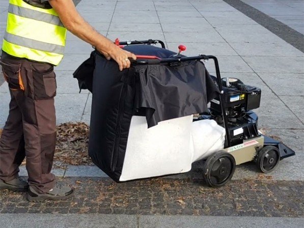 Een gemeentewerker gebruikt een bladzuiger van het merk Benassi om bladeren op te ruimen.