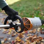 Persoon gebruikt de KMA 120 R CombiMotor om bladeren te blazen
