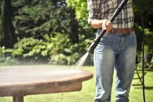 Vrouw reinigt tuintafel met STIHL RE 80 hogedrukreiniger