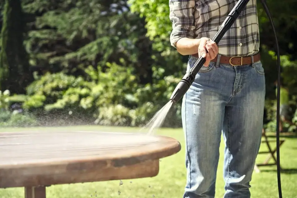 Vrouw reinigt tuintafel met STIHL RE 80 hogedrukreiniger