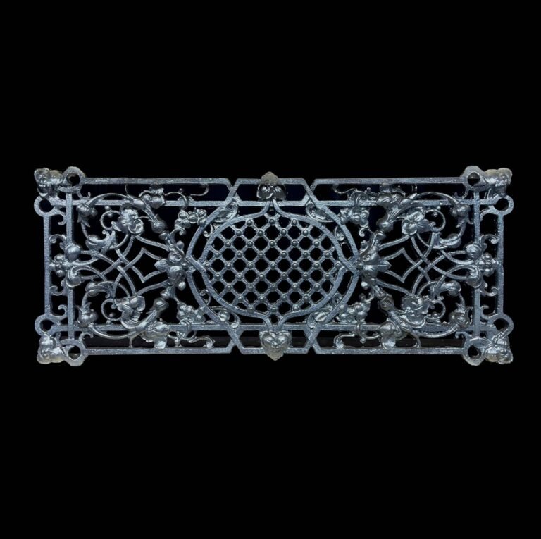 Een rechthoekig gietijzeren sierornament met een gedetailleerd patroon van bloemen, bladeren en een centraal ruitvormig raster, afgebeeld tegen een zwarte achtergrond.