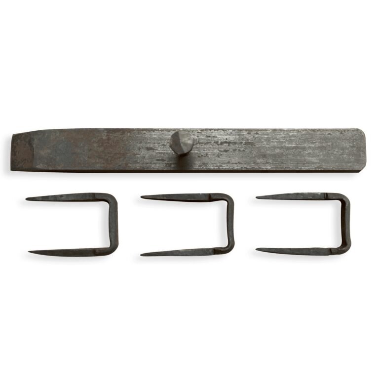 Bovenaanzicht van een handgesmede schuifgrendel met drie krammen, liggend op een witte achtergrond.