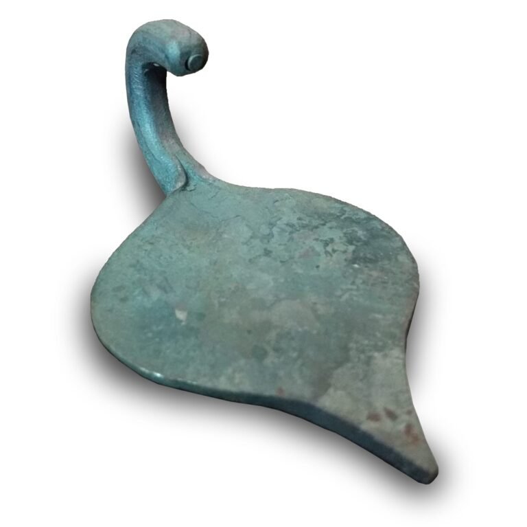 Een handgesmeed, bronskleurig ophanghaakje in de vorm van een blad, met een sierlijke krul bovenaan. Het haakje heeft een verweerde textuur en een donkere schaduw eronder.