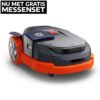 Een Segway Navimow X390 robotmaaier in donkergrijs en oranje, vanuit een schuine vooraanzicht, met een zwarte banner 'NU MET GRATIS MESSENSET' linksboven.