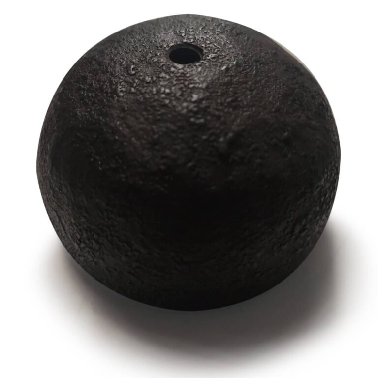Een donkere, getextureerde gietijzeren sierlijke eindbol met een klein gat aan de bovenkant, gefotografeerd tegen een witte achtergrond.