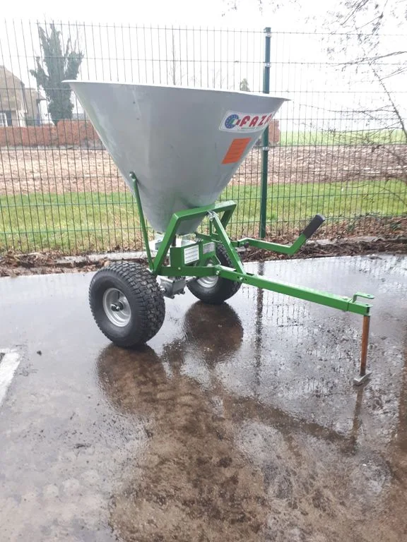 Faza getrokken strooier met gegalvaniseerde container op een groen frame, op straat