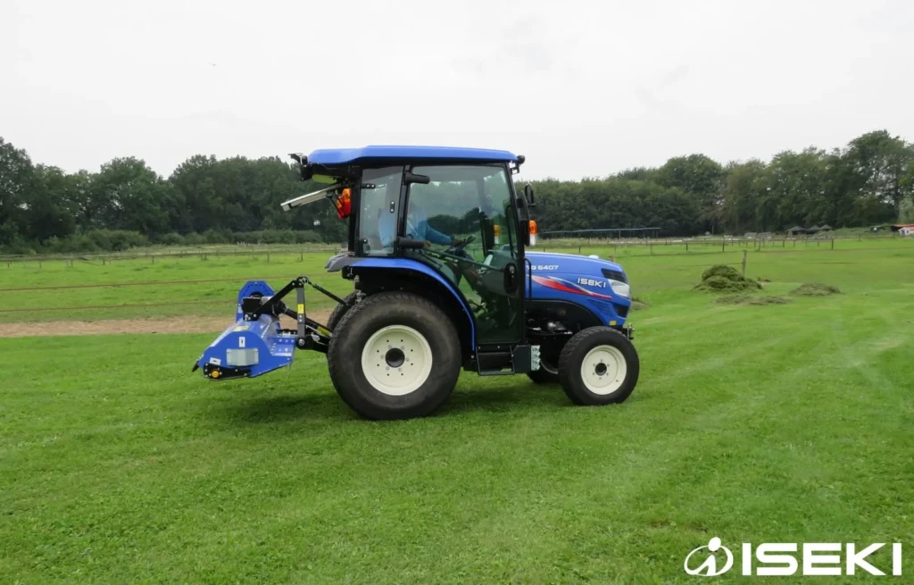 Iseki TG 6407 met cabine en klepelmaaier achterop op een grasveld