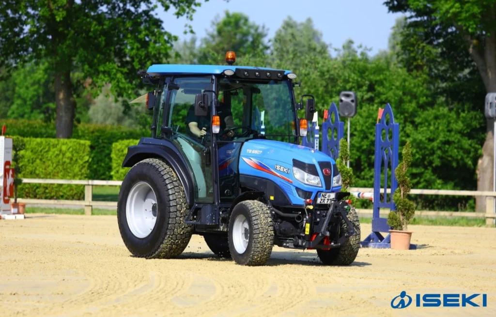 Iseki TG 6507 met cabine op een zandbaan, schuin van voren gezien
