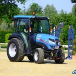 Iseki TG 6507 met cabine op een zandbaan, schuin van voren gezien