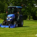 Iseki TG 6507 met cabine en een blauw maaidek voorop op een grasveld