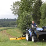 Iseki TLE 3410 met veiligheidsbeugel, frontlader en een klepelmaaier in een weiland