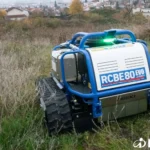 Voorkant van de RCBE 80 in hoog gras en onkruid met een groen signaallicht