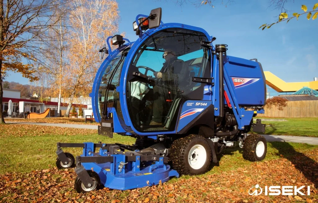 Iseki SF 544 met cabine en blauw maaidek tussen herfstbladeren