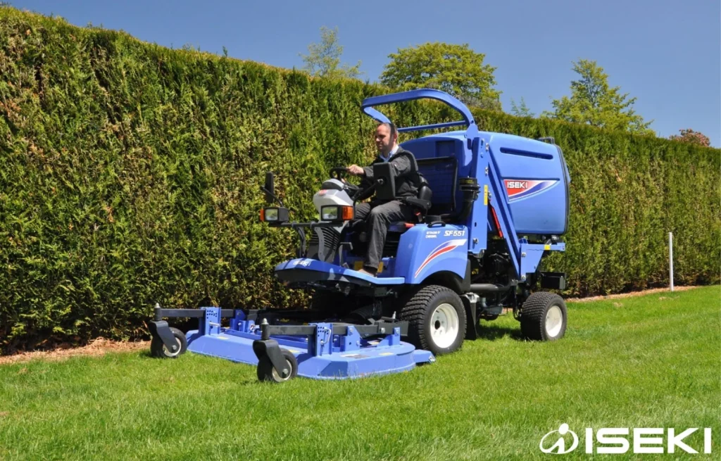 Iseki SF 551 met blauw maaidek langs een haag