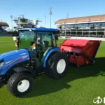 Iseki TG 6687 met cabine en een rode machine achterop op een grasveld
