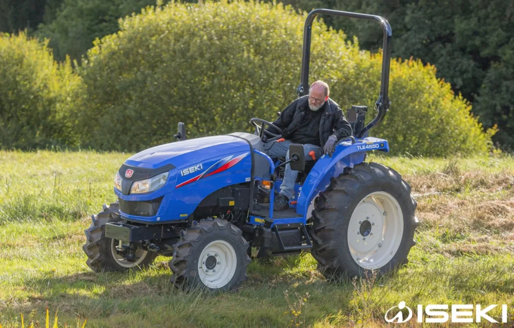 Iseki TLE 4550 met bestuurder op een grasveld, schuin van voren gezien