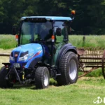 Iseki TG 6507 met cabine en een hooiharkmachine achterop in een weiland