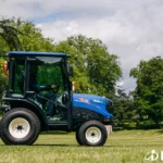 Zijkant van de TM 4270 met cabine op een gemaaid grasveld