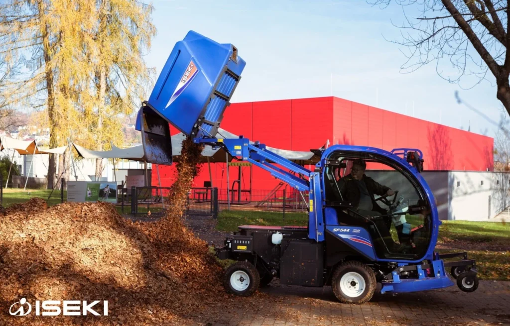 Iseki SF 544 met cabine leegt de opvangbak in een berg bladeren
