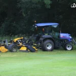 Iseki TG 6687 met cabine en een grote gele klepelmaaier aan de zijkant op een grasveld