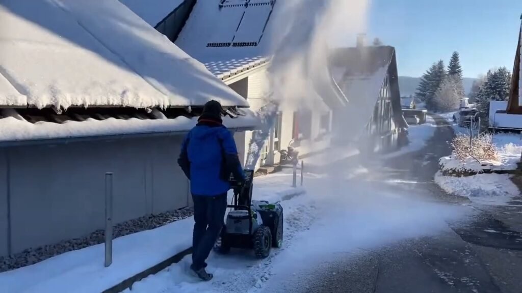 Sneeuwfrees die de sneeuw in een boog opzij werpt