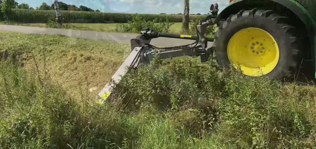 Jansen AGF bermmaaier die met gekantelde kop de helling van een slootkant maait