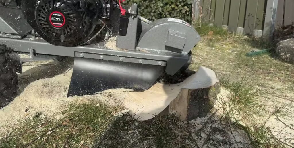 Jansen stobbenfrees met eigen benzinemotor naast een half weggefreesde boomstronk