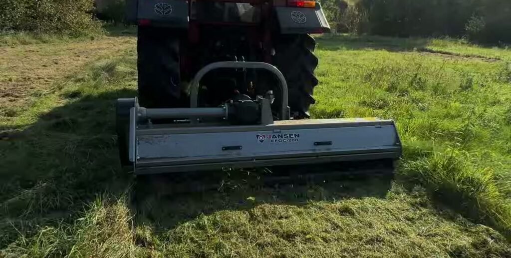 Jansen EFGC-200 achter een trekker in een weiland, met de aftakas naar de maaier