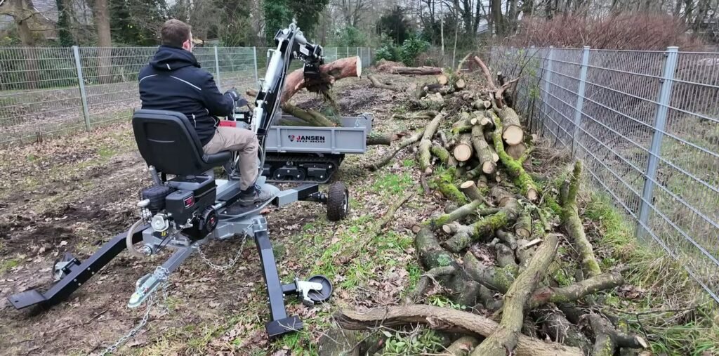 Jansen MB-360 met een grijper tilt een boomstam boven een rupsdumper