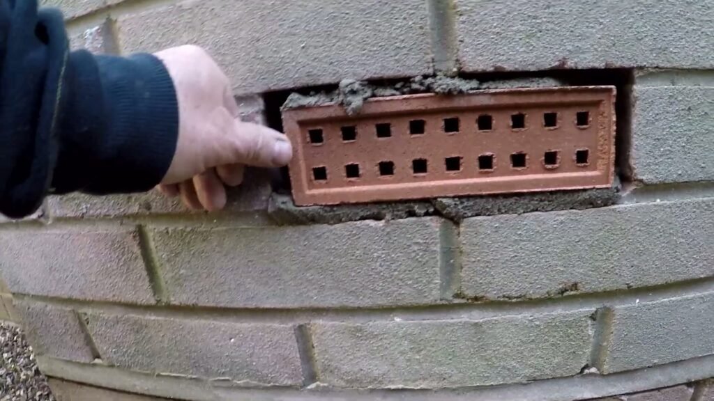 Ventilatiesteen die in een opening van één steenhoogte in een bakstenen muur wordt gezet