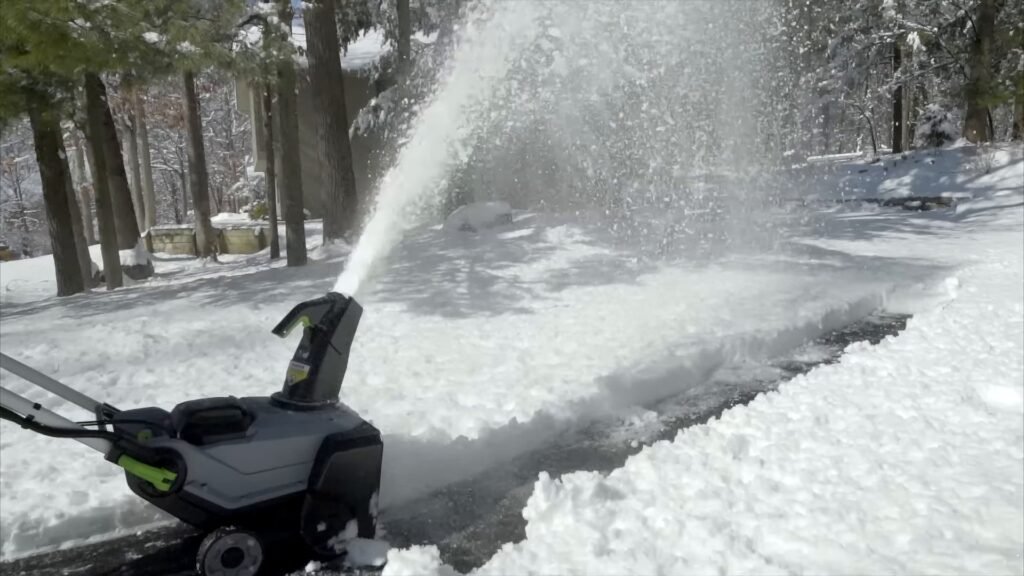 Sneeuwschuif of sneeuwfrees: een oprit die na sneeuwval half is geruimd, met de sneeuw in een boog opzij geworpen