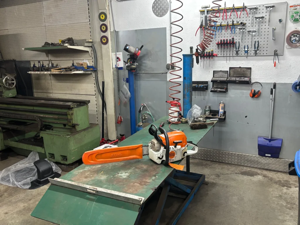 STIHL kettingzaag op de heftafel in de werkplaats, met het gereedschapsbord erachter